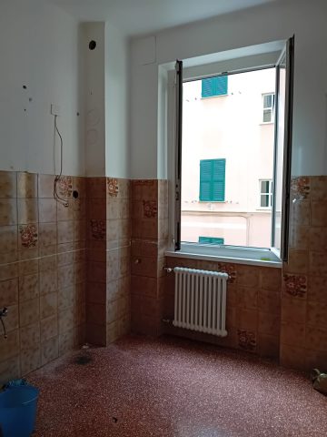 La cucina - pavimento in graniglia rosso mattone e piastrelle marrone cotto a parete